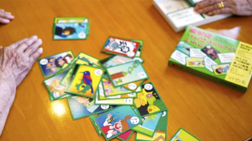 入居者がカードゲームやレクリエーション活動に参加している様子